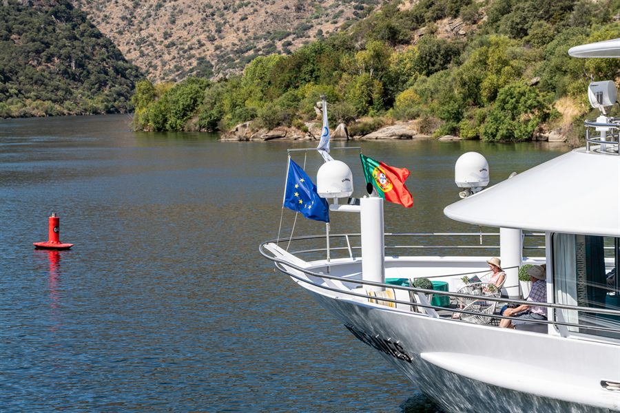 River cruise ship deck with flags on the Douro River in Portugal
