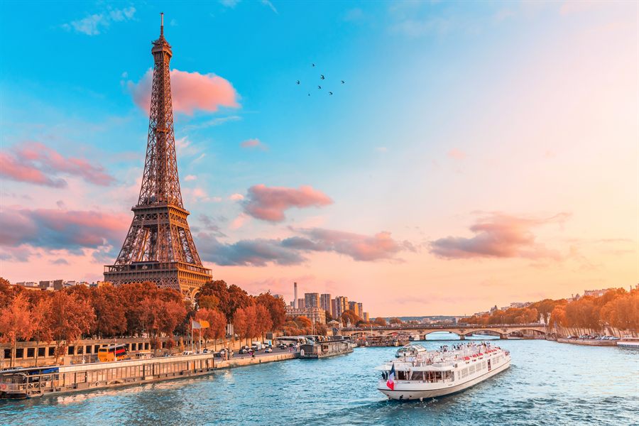 Eiffel Tower at sunset with a river boat on the Seine in Paris