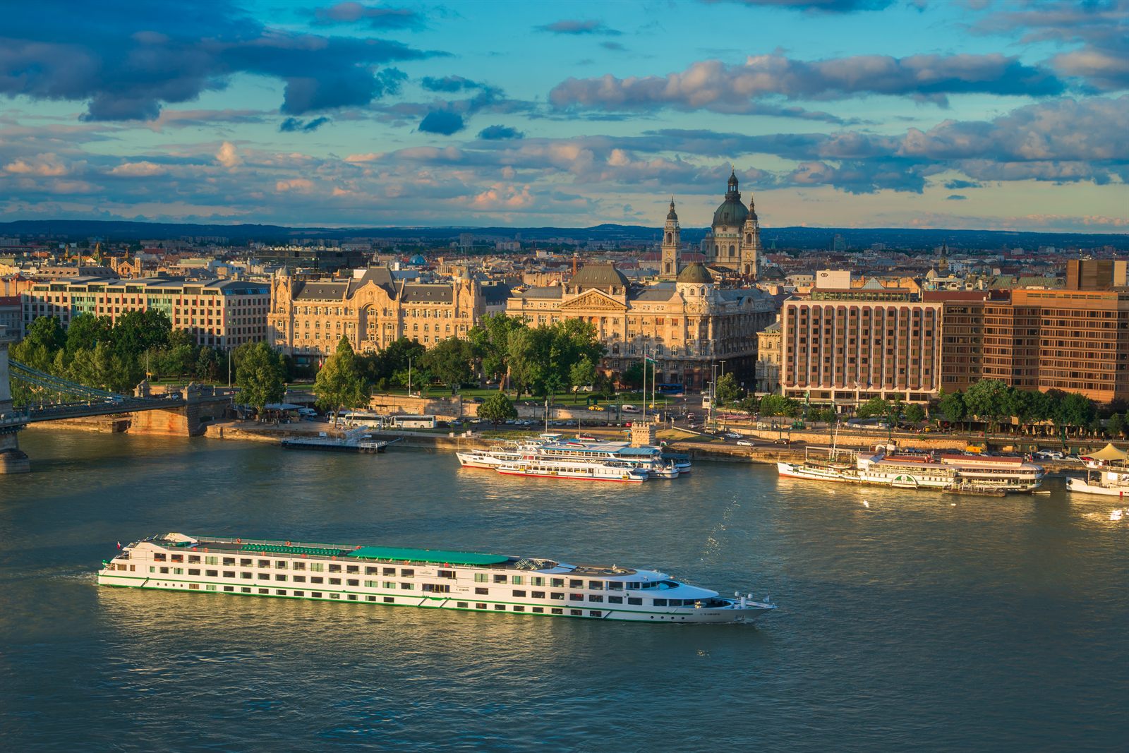 River cruise ship on the Danube in front of the Budapest riverfront at sunset